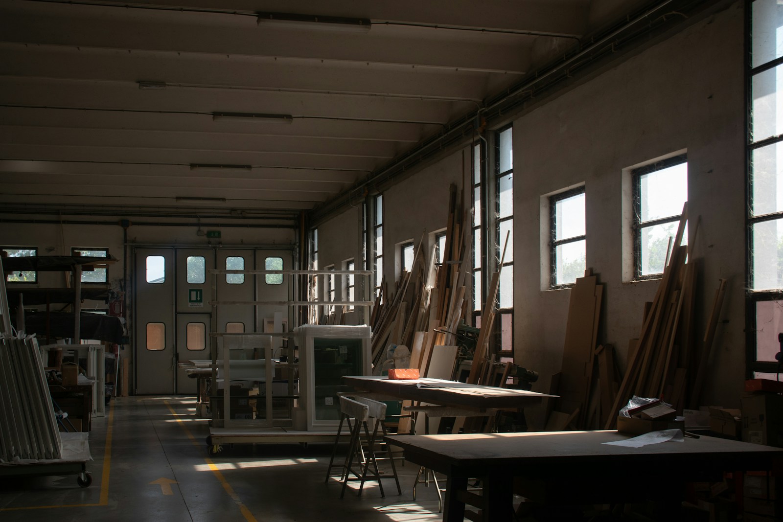 A working woodshop with lumber, benches, and production equipment